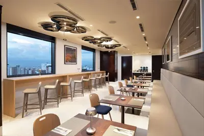 a restaurant with tables and chairs and large windows at Homewood Suites By Hilton Santo Domingo in Santo Domingo