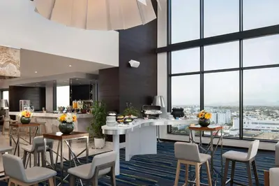 a kitchen with a counter and chairs and windows at Homewood Suites By Hilton Santo Domingo in Santo Domingo