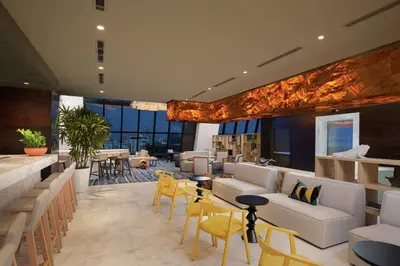 a hotel lobby with white couches and yellow chairs at Homewood Suites By Hilton Santo Domingo in Santo Domingo