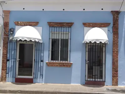 a blue building with two windows with bars at La Aldea in Santo Domingo