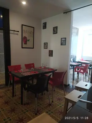 a dining room with a table and red chairs at La Aldea in Santo Domingo