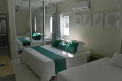 a bedroom with two beds and a mirror at Villa Deluxe Costambar in San Felipe de Puerto Plata