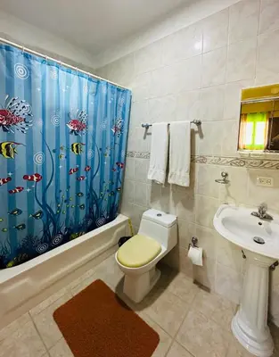 a bathroom with a toilet and a shower curtain at Apartmenthotel Michaela in Sosúa