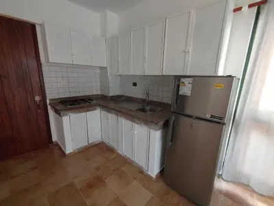 a kitchen with white cabinets and a stainless steel refrigerator at Residence Meridiana in Juan Dolio