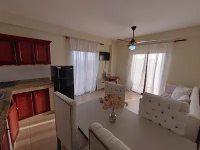 a kitchen and living room with a table and chairs at Residence Meridiana in Juan Dolio