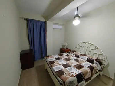 a bedroom with a bed and a blue curtain at Residence Meridiana in Juan Dolio