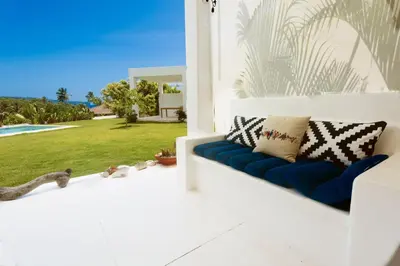 a blue couch on a porch with a view of a yard at Casa Blava with AC in Las Galeras