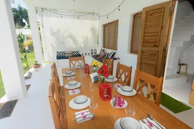 a dining room with a wooden table and chairs at Villa Cuatro Peces in Las Galeras