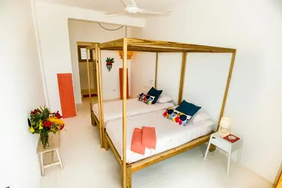 a bedroom with a wooden canopy bed with pillows at Villa Cuatro Peces in Las Galeras