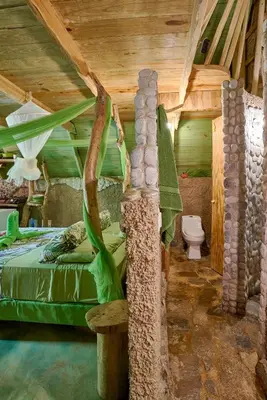 a bedroom in a tree house with a bed and a toilet at CHALET TROPICAL Hotel & Pool Bar Restaurant in Las Galeras