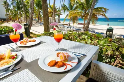 a table with plates of food and drinks on the beach at Beach Apartment - Marbella, Juan Dolio!! Getaway Offer!! in Juan Dolio