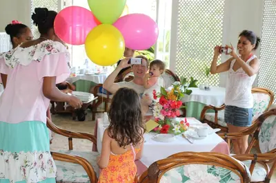 a group of children taking pictures of a table with balloons at Hotel Villa Serena in Las Galeras
