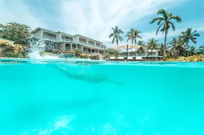 a shark swimming in the water in front of a house at Hotel Villa Serena in Las Galeras