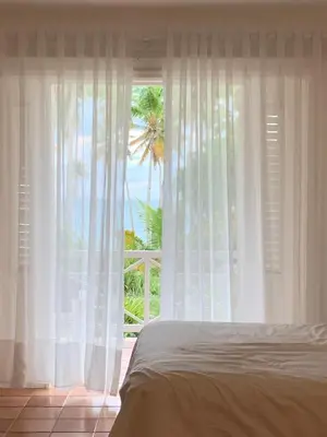 a bedroom with a window with a view of the ocean at Hotel TODOBLANCO, Las Galeras, SAMANA in Las Galeras
