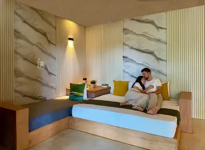 a man and a woman sitting on a bed at Las Galeras Village Ecolodge in Las Galeras