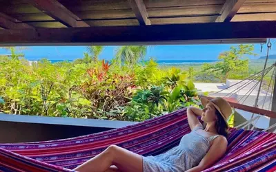 a woman laying in a hammock on a resort at Las Galeras Village Ecolodge in Las Galeras