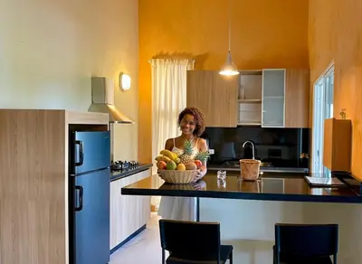 a woman standing in a kitchen with a bowl of fruit at Las Galeras Village Ecolodge in Las Galeras