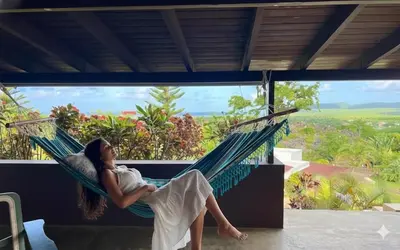 a woman laying in a hammock on a house at Las Galeras Village Ecolodge in Las Galeras
