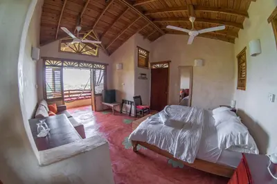a bedroom with a bed and a living room at Paraiso Caño Hondo in Los Guineos Perdidos