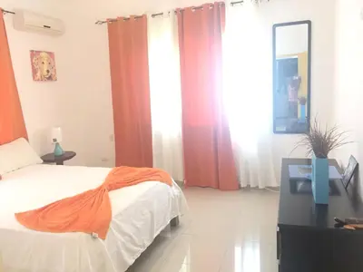 a bedroom with orange and white curtains and a bed at Elegant Villa with Sea View in Sosúa | Private Pool in Sosúa