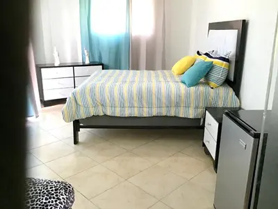 a bedroom with a bed with colorful pillows on it at Elegant Villa with Sea View in Sosúa | Private Pool in Sosúa