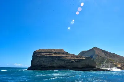 a rock in the ocean with a blue sky at El Morro Eco Adventure Hotel in San Fernando de Monte Cristi