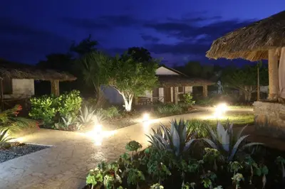 a garden with lights in a resort at night at El Morro Eco Adventure Hotel in San Fernando de Monte Cristi