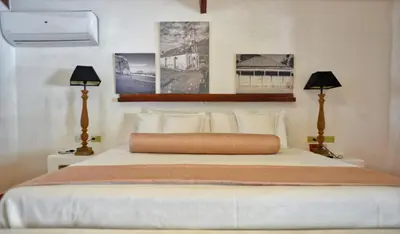 a bedroom with a white bed with two lamps at El Morro Eco Adventure Hotel in San Fernando de Monte Cristi