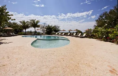 a swimming pool on the beach with lounge chairs at El Morro Eco Adventure Hotel in San Fernando de Monte Cristi