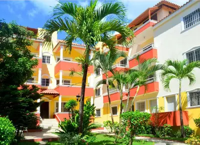 a building with palm trees in front of it at Parco del Caribe in Boca Chica