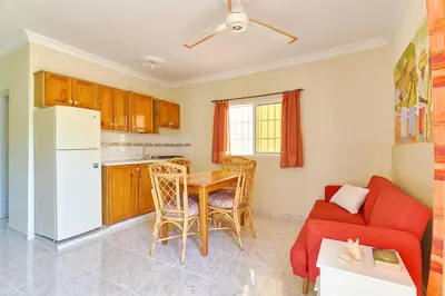 a living room with a red couch and a table at Parco del Caribe in Boca Chica