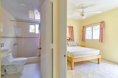 a bedroom with a bed and a bathroom with a shower at Parco del Caribe in Boca Chica