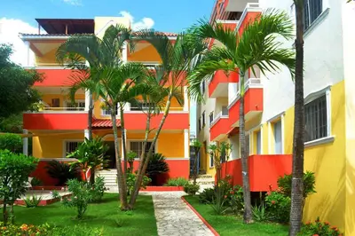 a building with palm trees in front of it at Parco del Caribe in Boca Chica