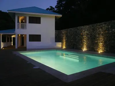 a swimming pool in front of a house at night at Villa Noria in Las Terrenas