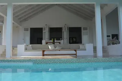 a living room with a couch and a swimming pool at Villa Noria in Las Terrenas