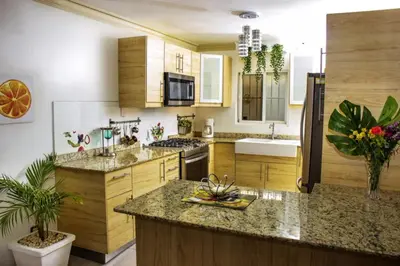 a kitchen with wooden cabinets and a large kitchen island at Home W Private Hot Tub, Near Everything in Sosua Center in Sosúa
