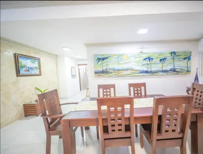 a dining room with a table and chairs and a painting at Home W Private Hot Tub, Near Everything in Sosua Center in Sosúa