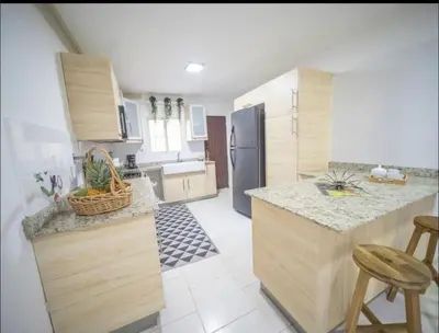 a kitchen with wooden cabinets and a counter top at Home W Private Hot Tub, Near Everything in Sosua Center in Sosúa