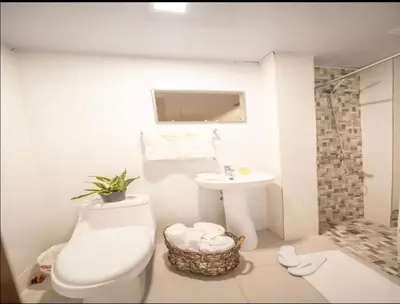 a white bathroom with a toilet and a sink at Home W Private Hot Tub, Near Everything in Sosua Center in Sosúa