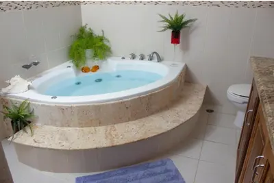 a bathroom with a tub with two plants in it at Home W Private Hot Tub, Near Everything in Sosua Center in Sosúa