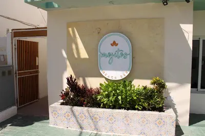 a sign on the side of a building with plants at Hotel Checkin El Cortecito in Punta Cana