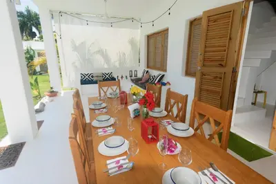 a dining room with a table with plates and wine glasses at Villa Kalfu with AC in Las Galeras