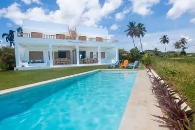 a villa with a swimming pool in front of a house at Villa Kalfu with AC in Las Galeras