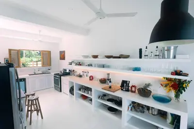 a kitchen with white shelves and a counter at Villa Kalfu with AC in Las Galeras