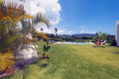a large yard with a swimming pool and a grass field at Villa Kalfu with AC in Las Galeras
