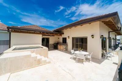 a patio with a table and chairs next to a house at Suites at Grand Laguna Beach by Calisto Stays in Sosúa