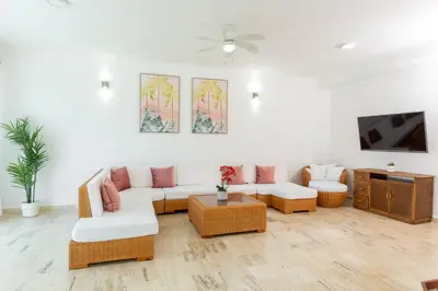 a living room with a couch and a tv at Suites at Grand Laguna Beach by Calisto Stays in Sosúa