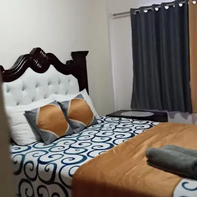 a bedroom with a bed with a black and white comforter at CONFORTABLE first floor en santiago RD in Santiago de los Caballeros