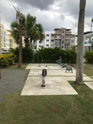 a park with benches and a basketball hoop and palm trees at moderno apto frente a la piscina in Santiago de los Caballeros