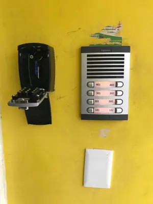 a pay phone sitting on a yellow wall at moderno apto frente a la piscina in Santiago de los Caballeros